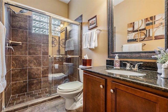 bathroom featuring a stall shower, vanity, and toilet