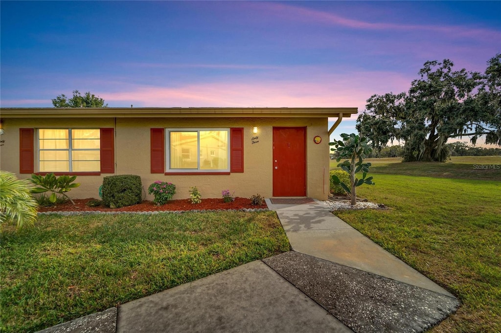 ranch-style home featuring a lawn