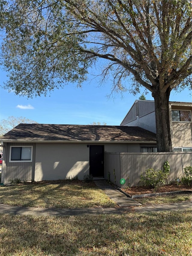 rear view of property featuring a lawn