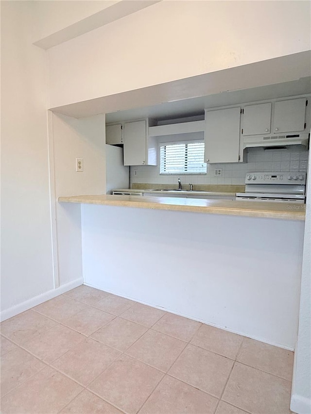 kitchen featuring light tile patterned flooring, white electric stove, and backsplash