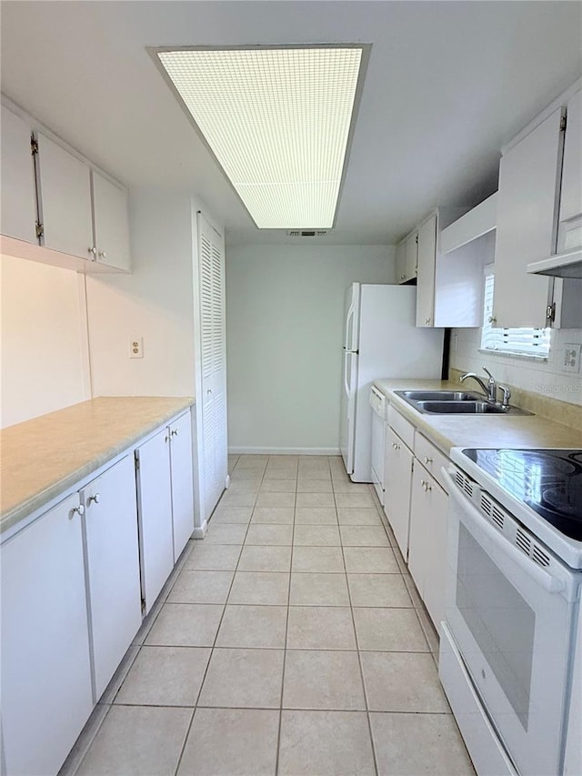 kitchen with white cabinetry, sink, light tile patterned floors, and white appliances