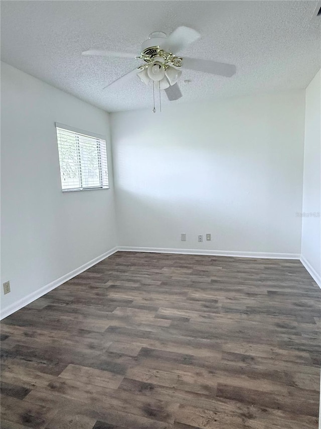 empty room with ceiling fan, dark hardwood / wood-style floors, and a textured ceiling