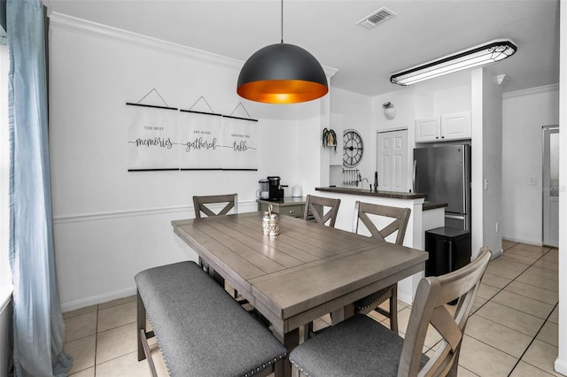 dining room featuring ornamental molding and light tile patterned floors