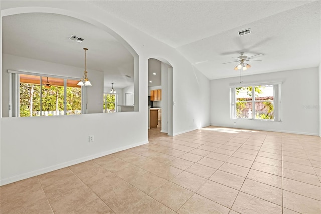 unfurnished room featuring light tile patterned floors, baseboards, visible vents, and a ceiling fan