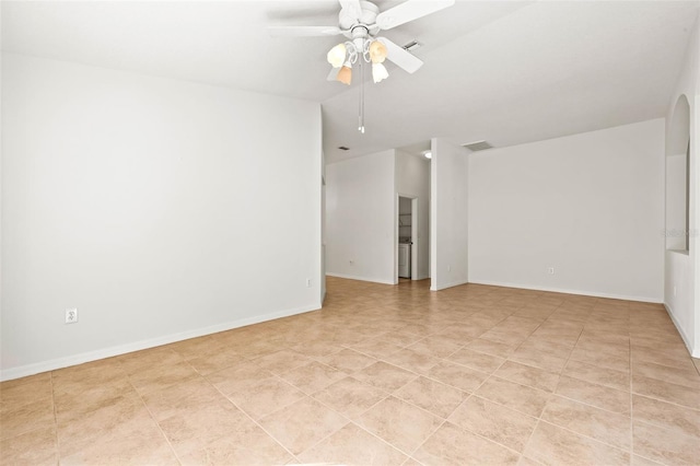 empty room with lofted ceiling, visible vents, baseboards, and a ceiling fan