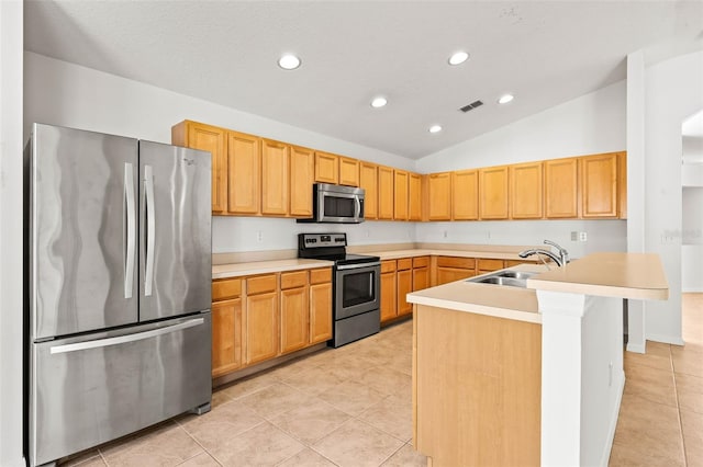 kitchen featuring sink, vaulted ceiling, a center island with sink, light tile patterned floors, and stainless steel appliances