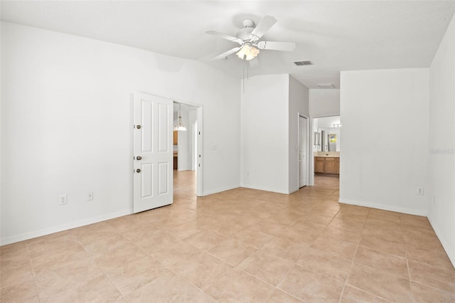 unfurnished room featuring visible vents, ceiling fan, and baseboards