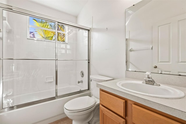 bathroom featuring vanity, toilet, and bath / shower combo with glass door