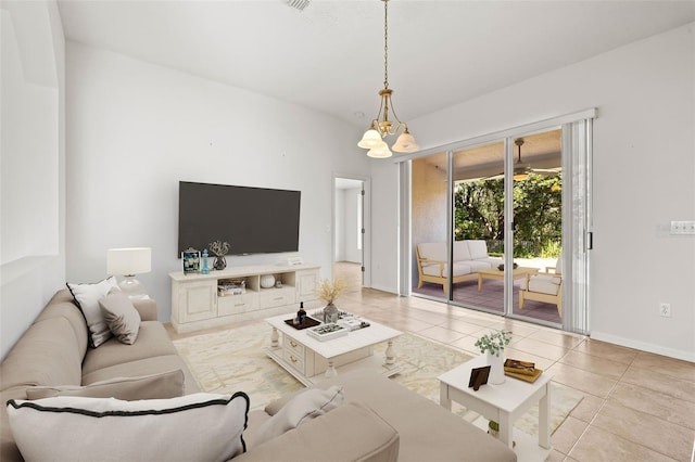 tiled living room with baseboards and a chandelier