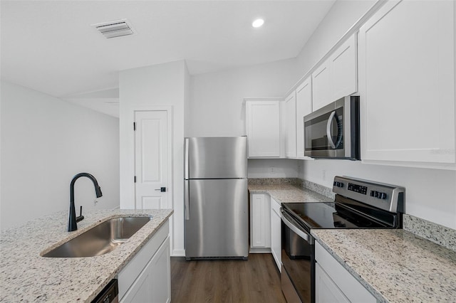 kitchen with light stone counters, white cabinetry, stainless steel appliances, and sink