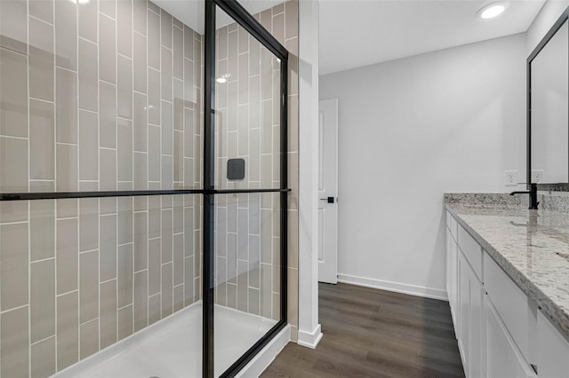 bathroom featuring hardwood / wood-style flooring, vanity, and a shower with shower door