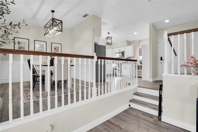 stairway featuring visible vents, recessed lighting, baseboards, and wood finished floors