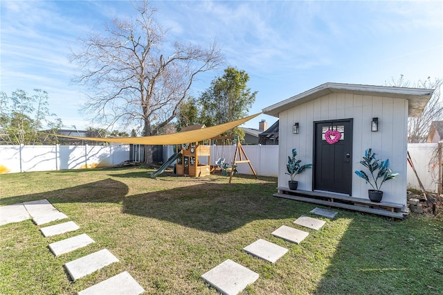 view of yard with a storage shed, an outdoor structure, a playground, and a fenced backyard