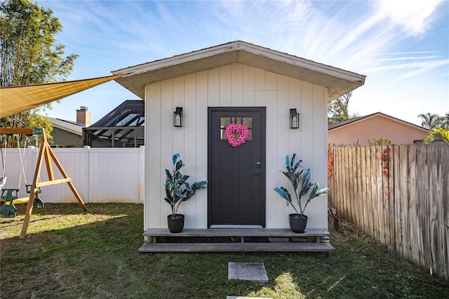 view of shed featuring a fenced backyard and a playground