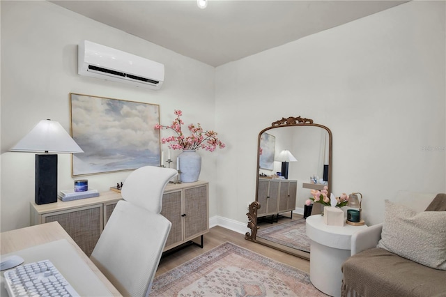 office area with a wall mounted air conditioner, baseboards, and light wood-style floors