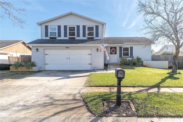 view of front of property with concrete driveway, fence, a garage, and a front lawn