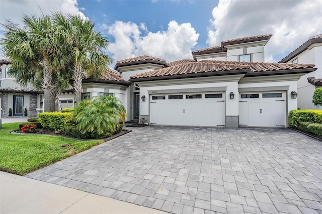 mediterranean / spanish-style house with a garage and a front yard