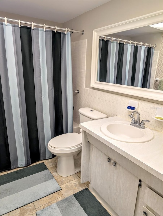 bathroom with vanity, toilet, tile walls, and backsplash