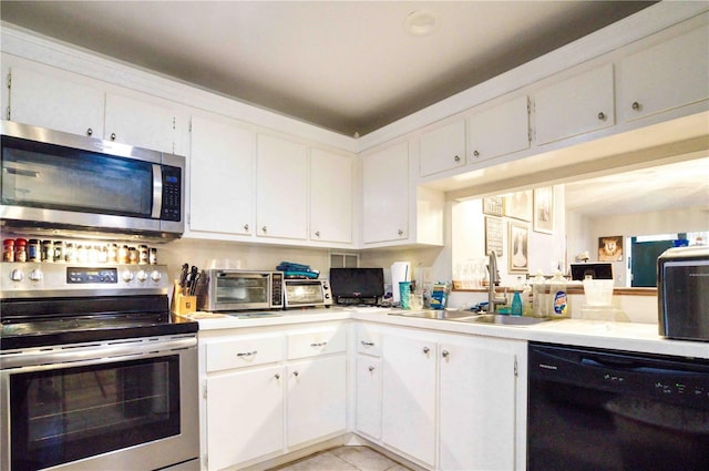 kitchen featuring white cabinetry, appliances with stainless steel finishes, sink, and light tile patterned floors