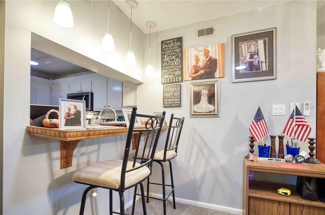 kitchen with pendant lighting and carpet floors