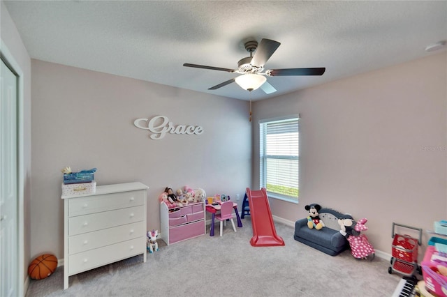 rec room featuring ceiling fan, light carpet, and a textured ceiling