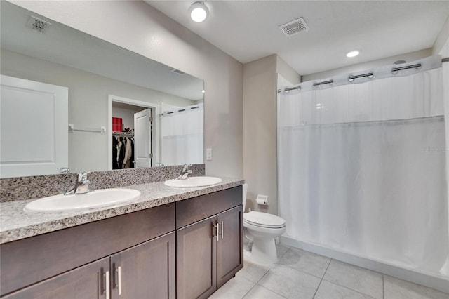 bathroom with toilet, tile patterned flooring, curtained shower, and vanity