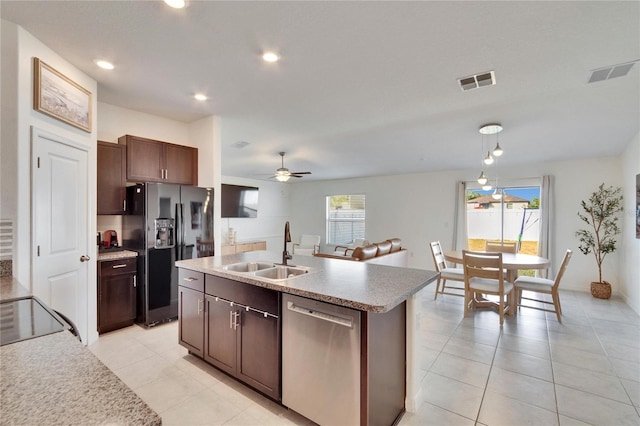 kitchen featuring an island with sink, sink, black refrigerator with ice dispenser, stainless steel dishwasher, and dark brown cabinets