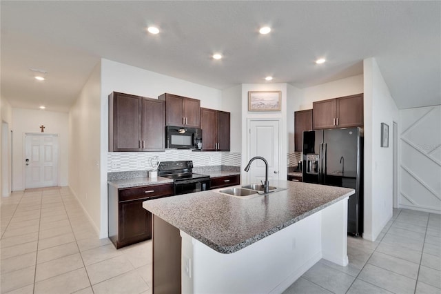 kitchen featuring a kitchen island with sink, black appliances, sink, tasteful backsplash, and light tile patterned floors