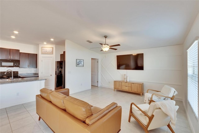 tiled living room with sink, lofted ceiling, and ceiling fan