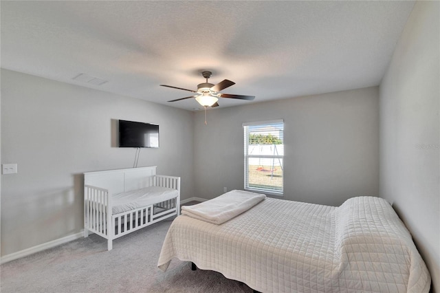 carpeted bedroom with a textured ceiling and ceiling fan