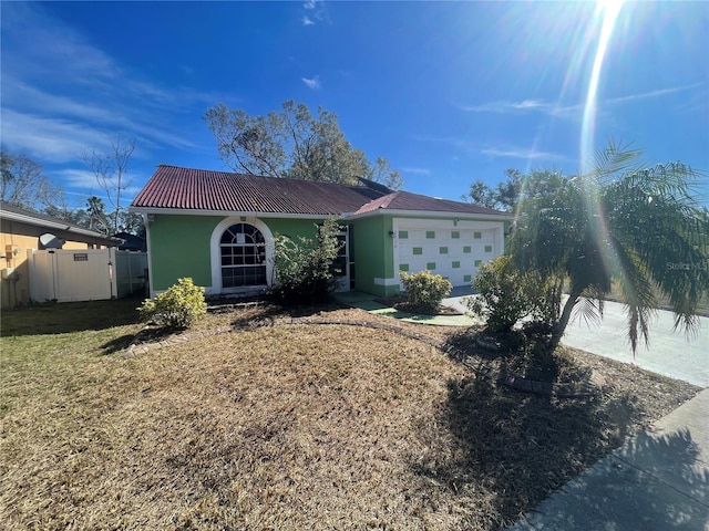 single story home featuring a garage and a front lawn