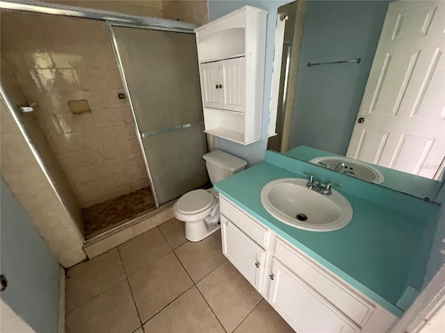 bathroom with a shower with door, vanity, tile patterned flooring, and toilet