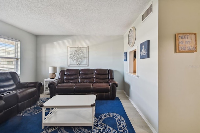 living room featuring light wood-type flooring and a textured ceiling