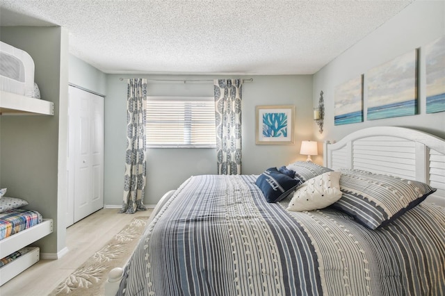 bedroom featuring a textured ceiling, light hardwood / wood-style floors, and a closet