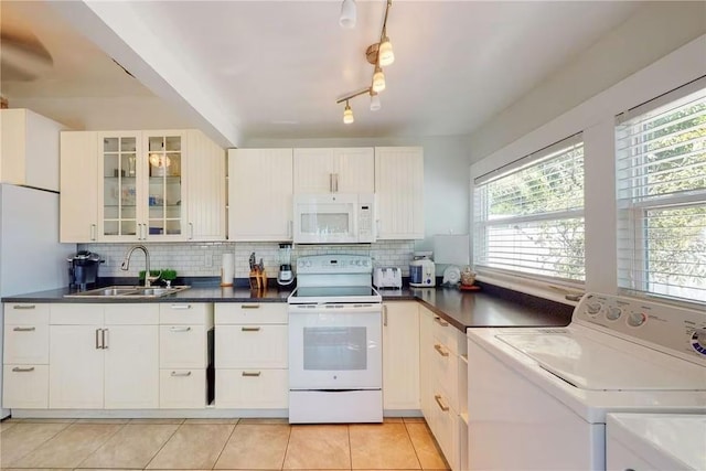 kitchen featuring sink, white appliances, light tile patterned floors, white cabinets, and decorative backsplash