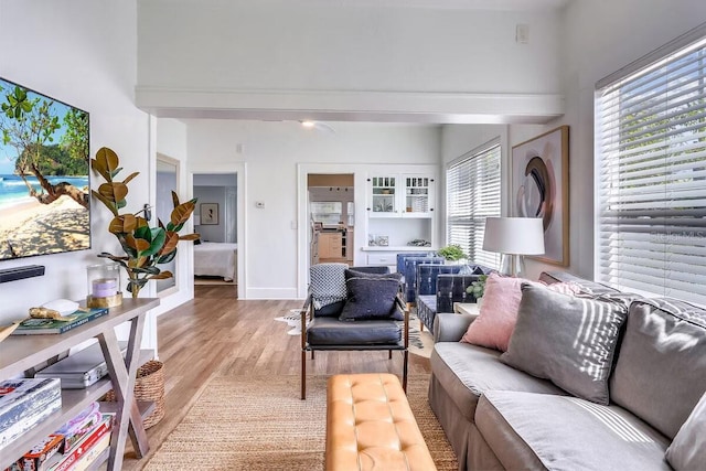 living room featuring a towering ceiling and light hardwood / wood-style flooring