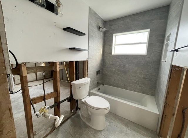 bathroom with tiled shower / bath combo and toilet