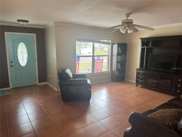 entrance foyer featuring light tile patterned floors, ornamental molding, a textured ceiling, and ceiling fan