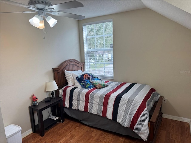 bedroom featuring wood-type flooring, vaulted ceiling, ceiling fan, and a textured ceiling