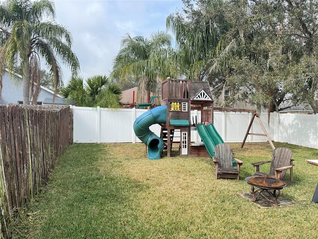 view of jungle gym featuring an outdoor fire pit and a yard