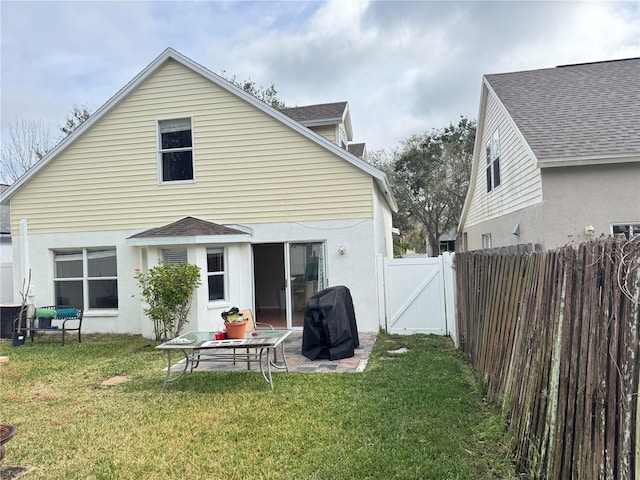 back of house with a patio area and a lawn