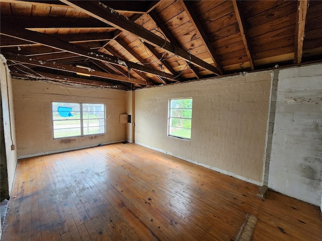 unfurnished room with lofted ceiling with beams, wood ceiling, and hardwood / wood-style floors