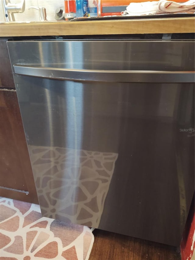 details featuring stainless steel dishwasher and dark hardwood / wood-style floors