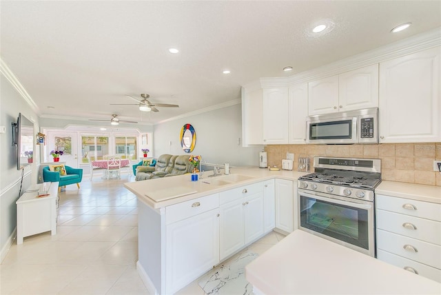 kitchen with white cabinetry, appliances with stainless steel finishes, sink, and kitchen peninsula