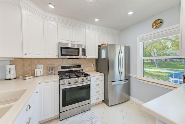 kitchen with stainless steel appliances, sink, white cabinets, and decorative backsplash