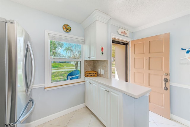 kitchen with stainless steel refrigerator, backsplash, kitchen peninsula, and white cabinets