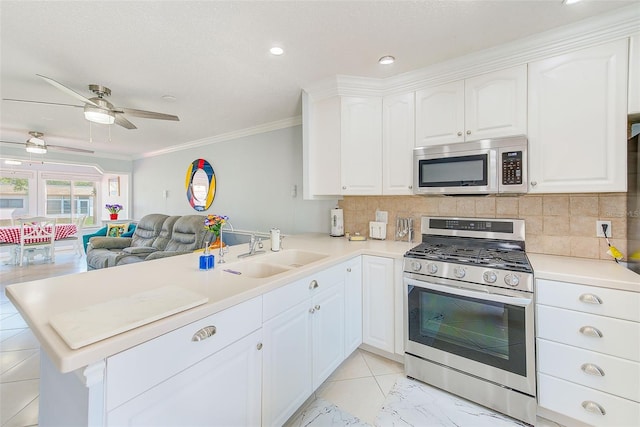 kitchen featuring sink, white cabinetry, appliances with stainless steel finishes, kitchen peninsula, and decorative backsplash