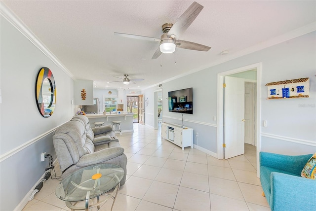 living room featuring crown molding, light tile patterned floors, ceiling fan, and a textured ceiling