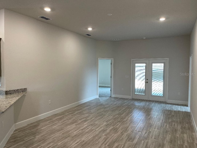 empty room with wood-type flooring and french doors