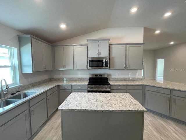 kitchen with stainless steel appliances, a kitchen island, sink, and gray cabinets